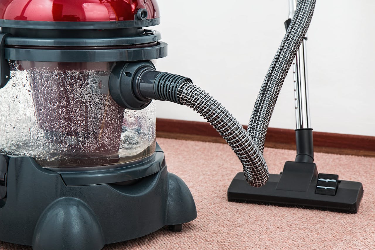 services-03 Close-up of a modern vacuum cleaner with water filtration on carpet floor indoors.